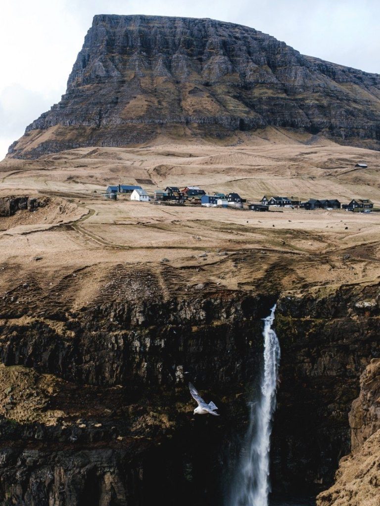 A photo of a mountain and waterfall in the Faroe Islands