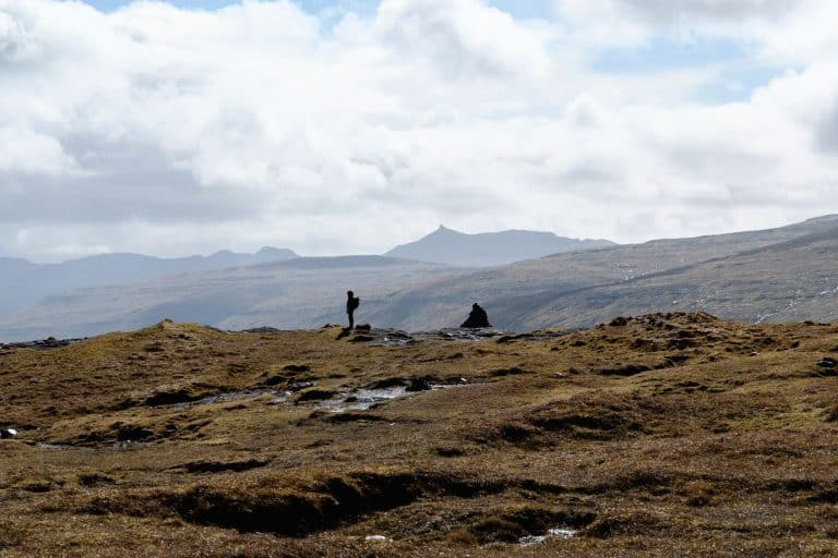 A person hiking Eiðiskollur in the Faroe Islands